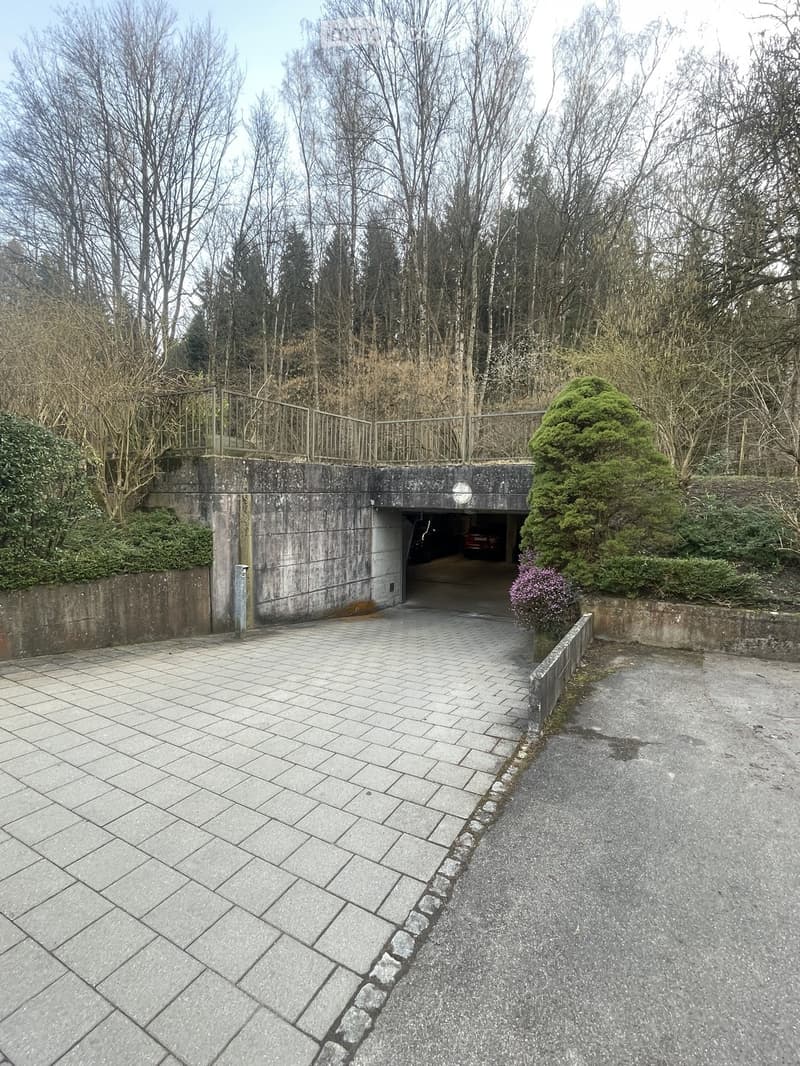 A concrete building with a tunnel entrance, leading to a parking area with a car parked inside.