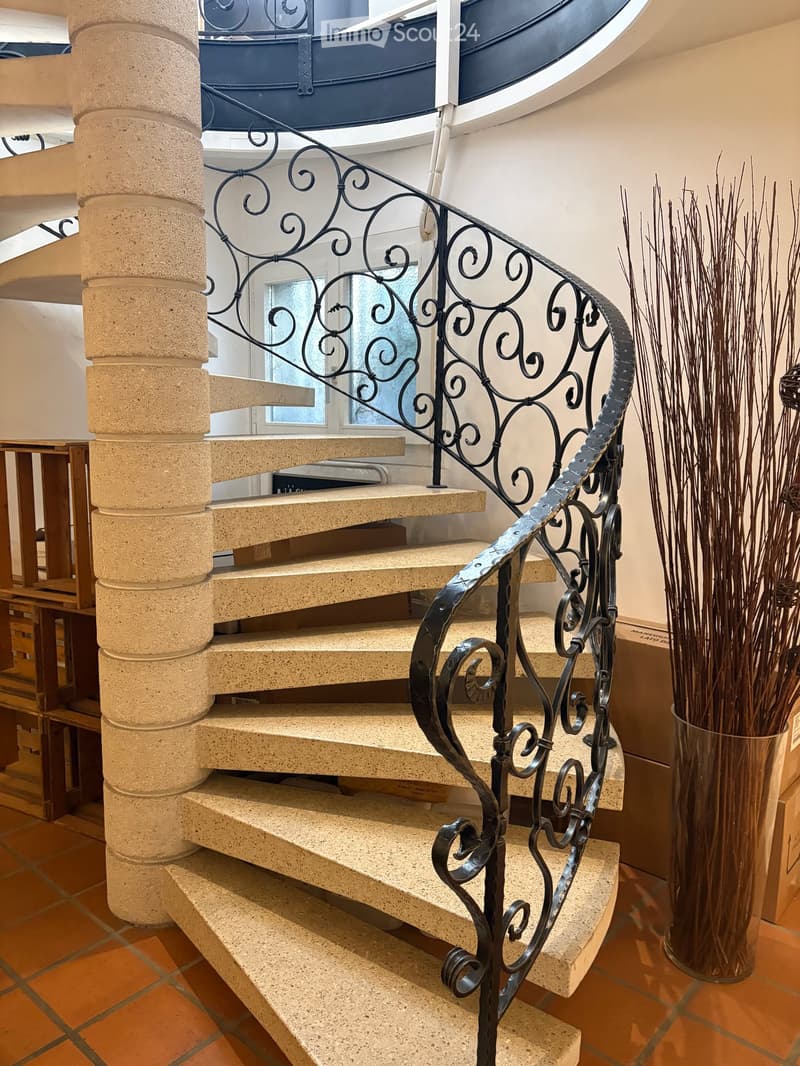 spiral staircase with concrete steps and black metal railing
