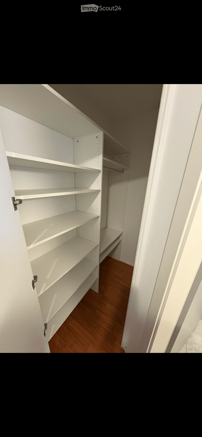 empty walk-in closet with white shelves and wooden floor