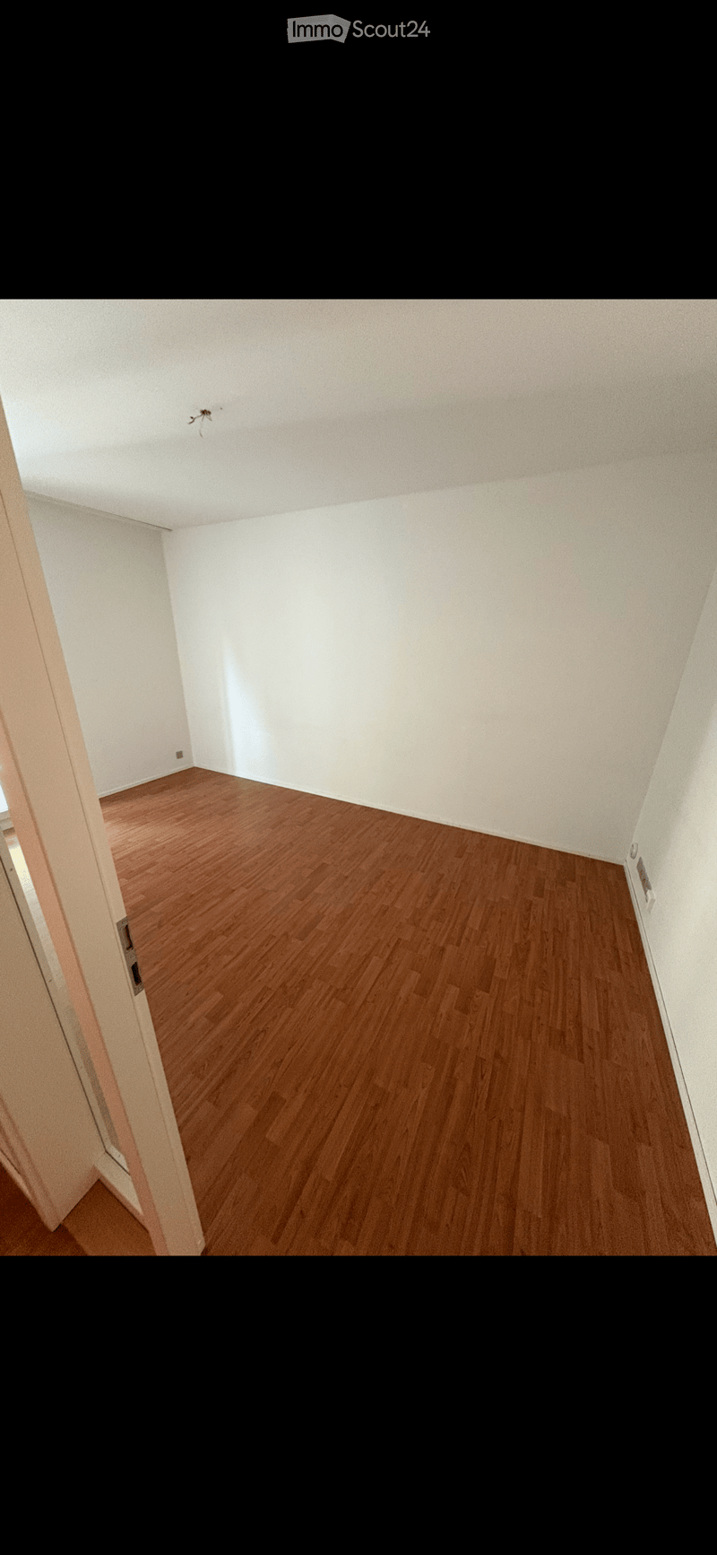 empty room, wooden floor, white walls, power outlet, door