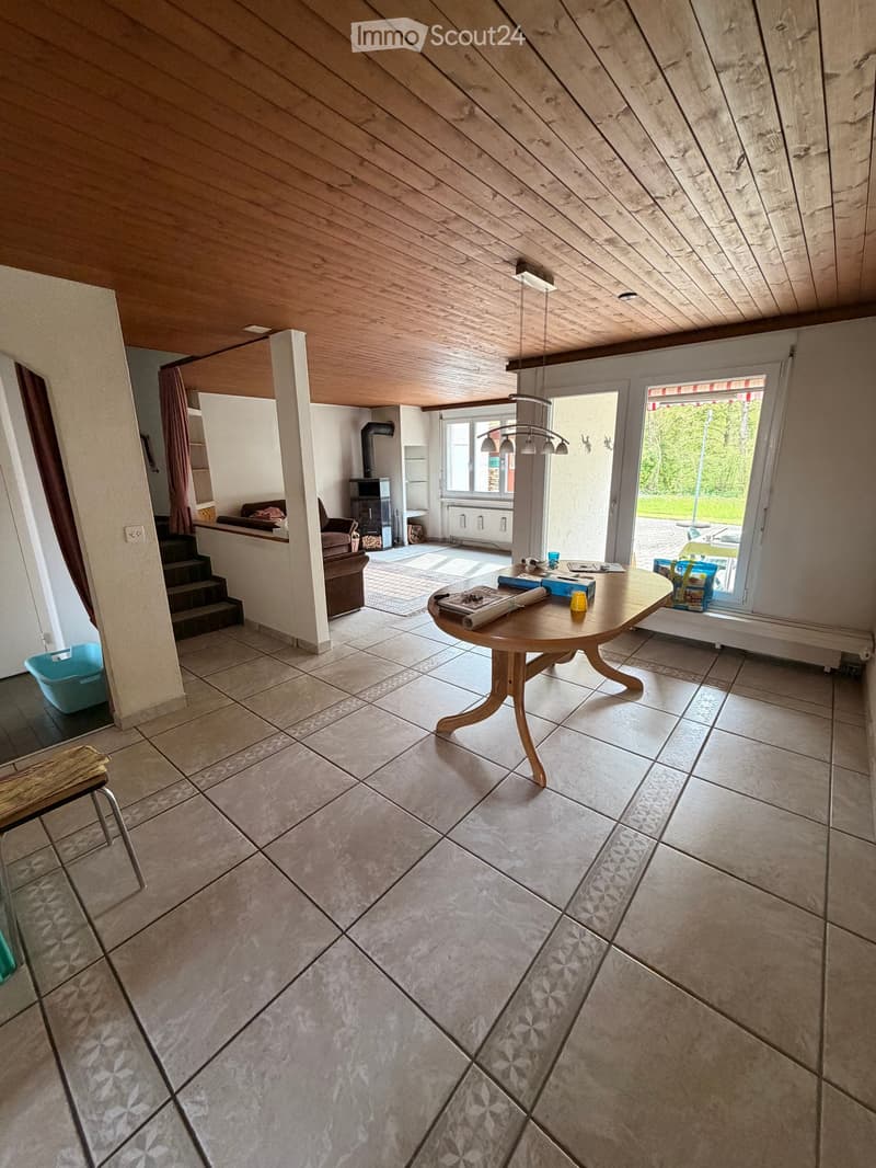 large room, wooden table, fireplace, large windows, tiled floor, stairs