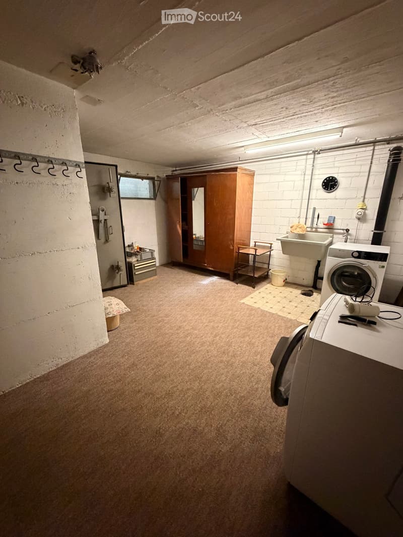 Laundry room with washing machine, sink, cabinet, and storage