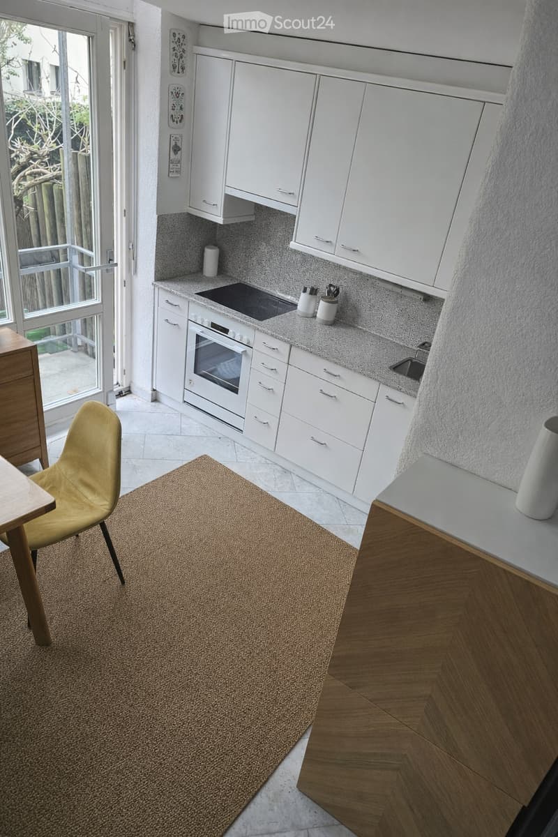modern kitchen with white cabinets, granite countertop, oven, sink, and a balcony