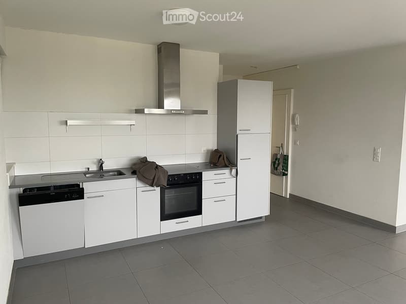 modern kitchen with white cabinets, stainless steel appliances, tiled floor, and a sink with a faucet