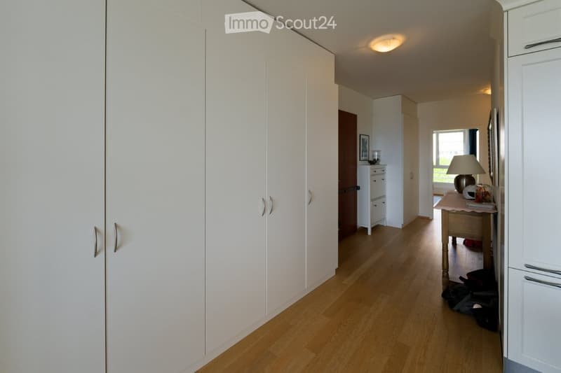 wooden floor, white wardrobes, white cabinets, table with lamp, picture frame, window