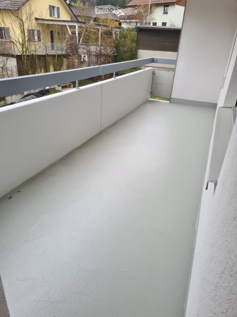 Balcony with white walls and floor, metal railing, empty