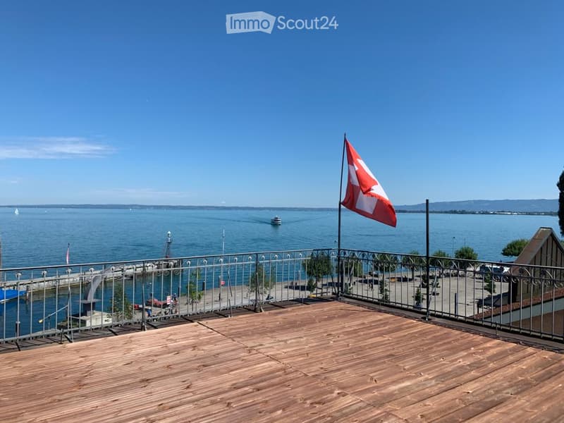 wooden deck, metal railing, flag, view of the sea