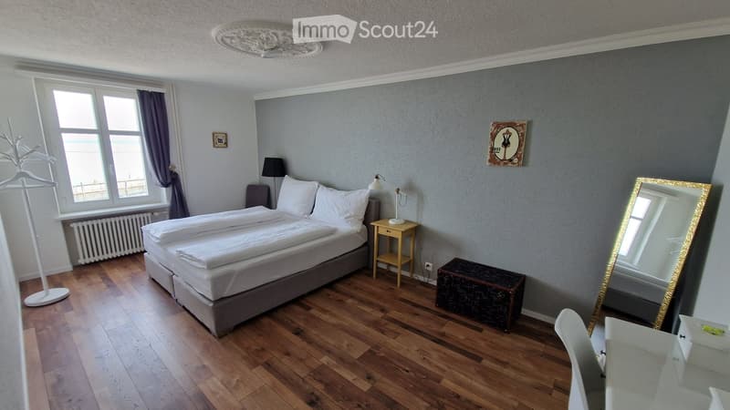 double bed, bedside tables, lamps, mirror, radiator, window, wooden floor