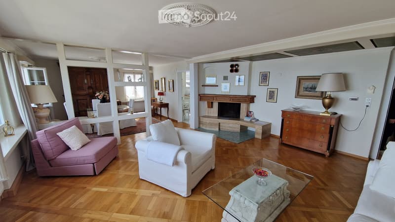 wooden floor, fireplace, white walls, white and pink couches, glass table, lamps, picture frames, wooden cabinet