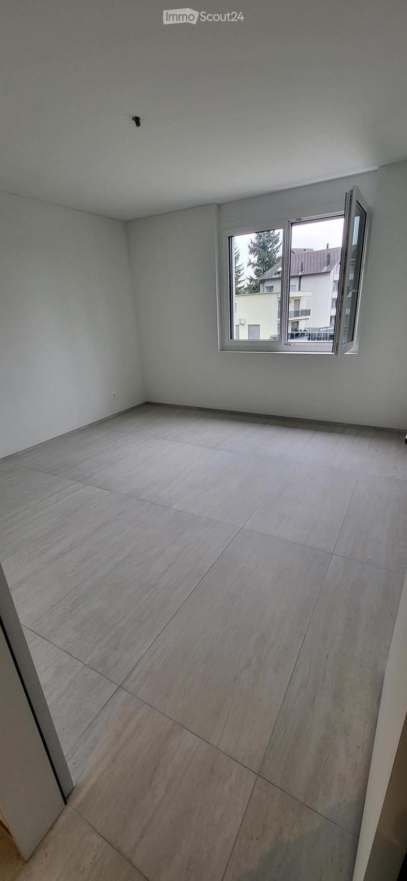 empty room, white walls, tiled floor, large window, view of trees and buildings