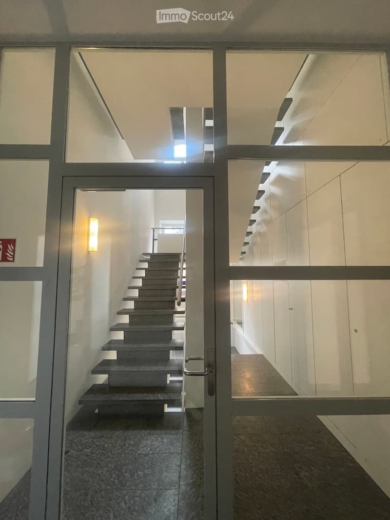 Entrance hall with staircase, glass doors, tiled floor, wall-mounted lights