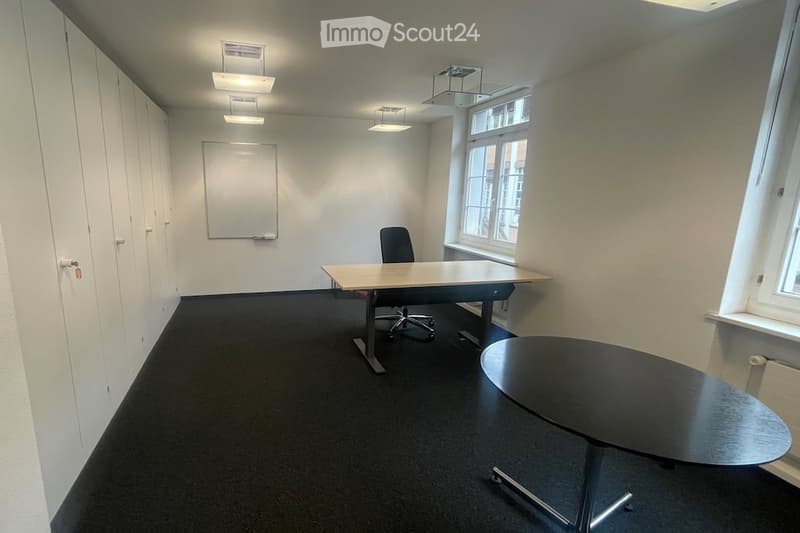 empty room, two desks, one chair, whiteboard, windows, ceiling lights