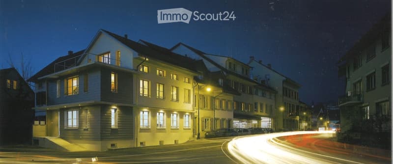 3 story house, white exterior, multiple windows, balcony, street lights, cars parked
