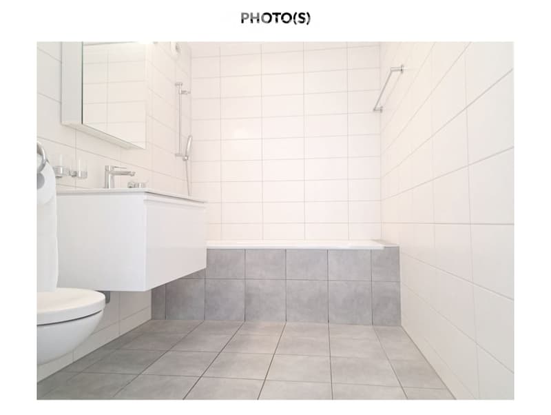 Bathroom with white tiles, white sink, white toilet, bathtub, shower head, mirror