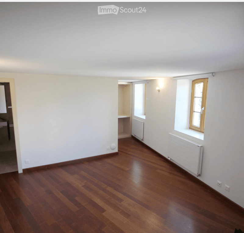 empty room, wooden floor, white walls, two windows, radiators, power outlets