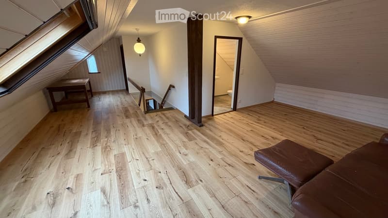 open layout with hardwood floors, couch, desk, bathroom