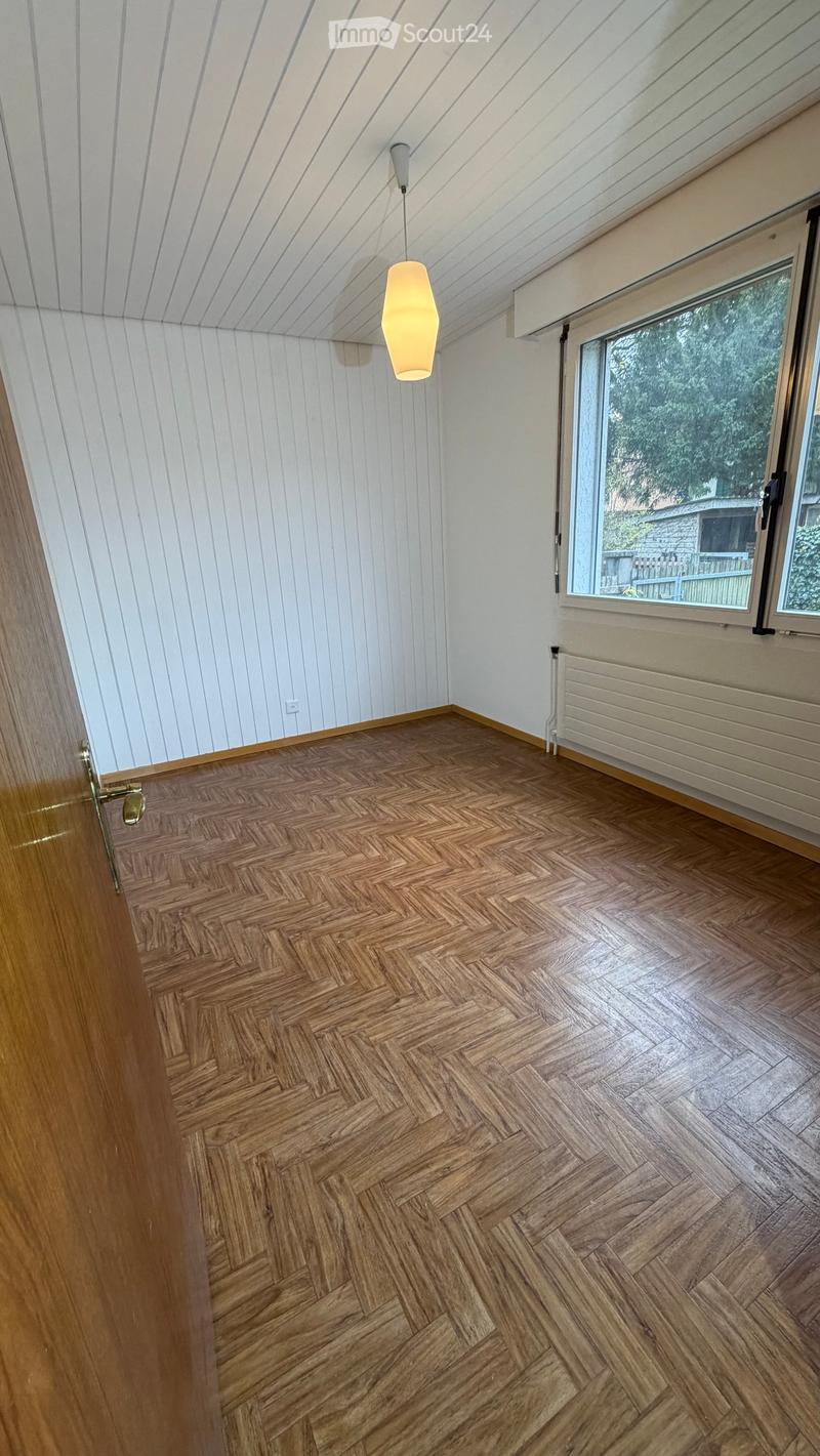 empty room, wooden floor, white walls, wooden door, large window, radiator, pendant lamp