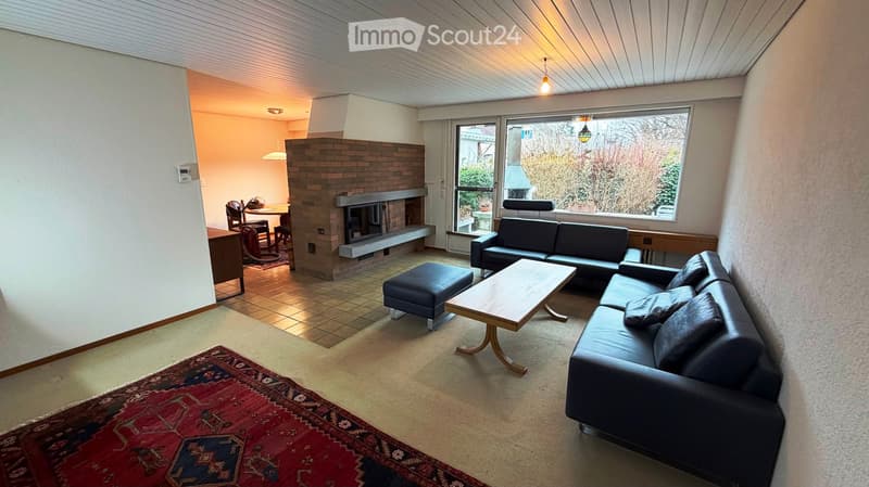 Blue couch, wooden coffee table, rug, fireplace, lamp