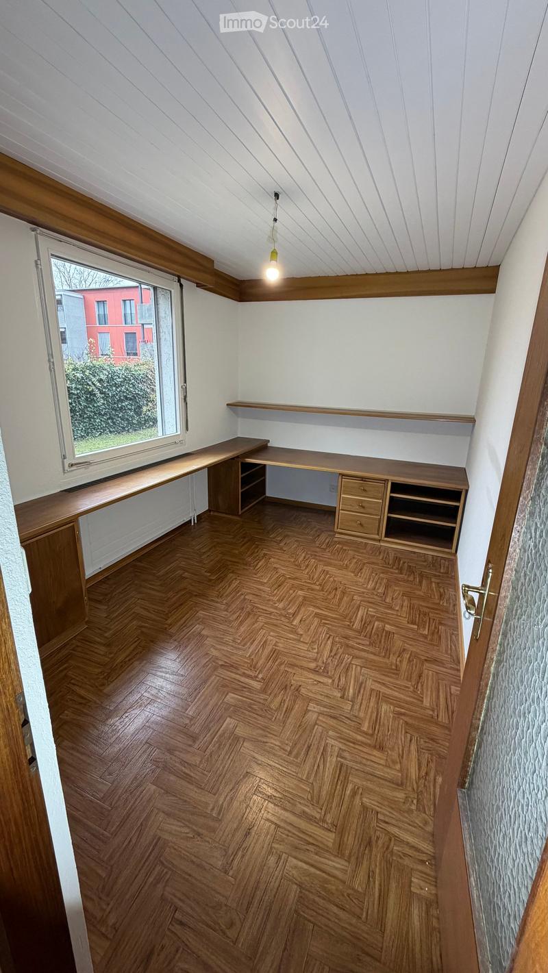 empty room, wooden floor, two wooden desks, window, shelves, open door