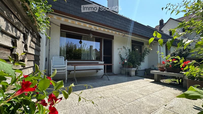 Outdoor patio with white chair, table, plants, and covered terrace