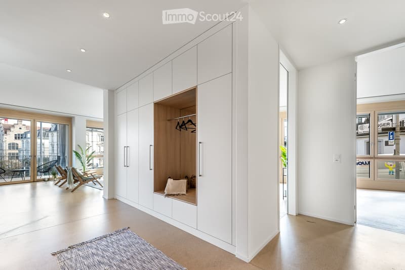modern room with white built-in wardrobes, wooden floor, glass doors, balcony, plants, chairs, rug