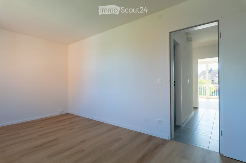 empty room, wooden floor, white walls, open door to balcony