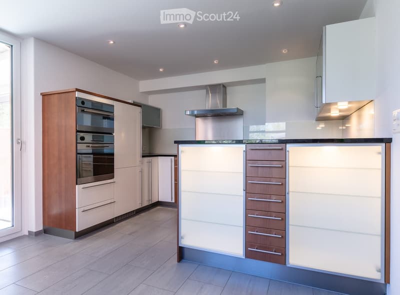 modern kitchen with wooden cabinets, white countertops, stainless steel appliances, glass door, tiled floor