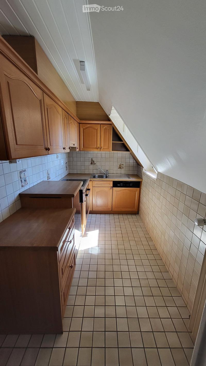 kitchen with wooden cabinets, tiled floor, sink, dishwasher, and a small window