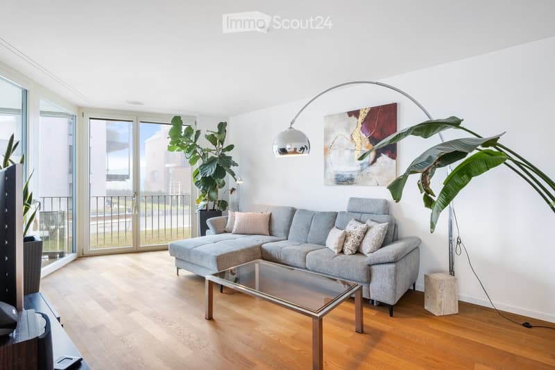living room, gray sectional sofa, glass coffee table, lamps, painting, plants, balcony, large windows