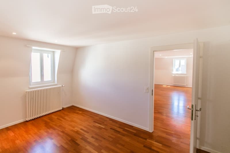empty room, wooden floor, white walls, window, radiator, open door