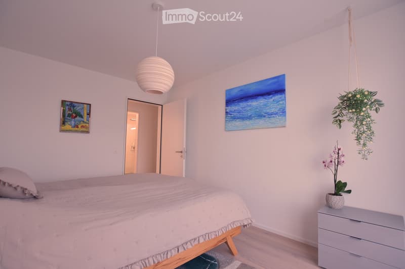 Bedroom with bed, nightstand, and artwork on the wall