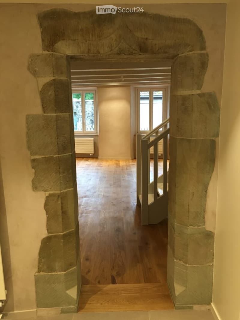 {"visible_features": ["Raised ground floor"],    "type": "Room",    "description": "stone archway, wooden floor, white painted wall, staircase, windows",    "localized_descriptions":        {        "EN": "Room: stone archway, wooden floor, white pai