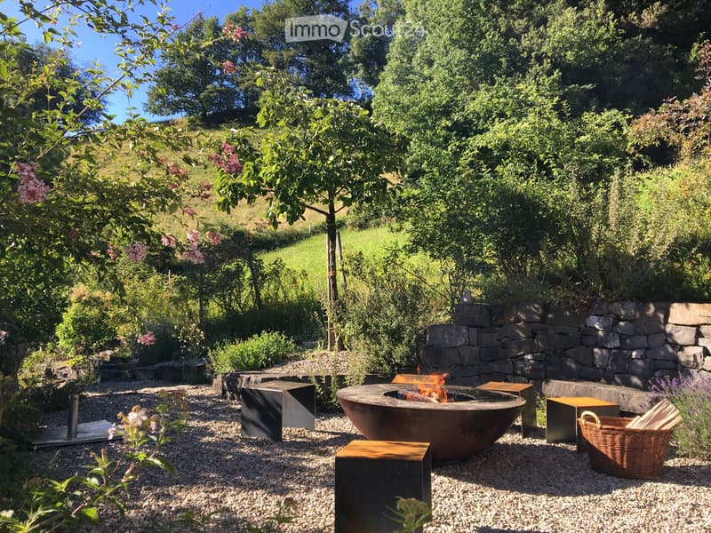 Outdoor area with a fire pit, wooden benches, and a basket of wood.