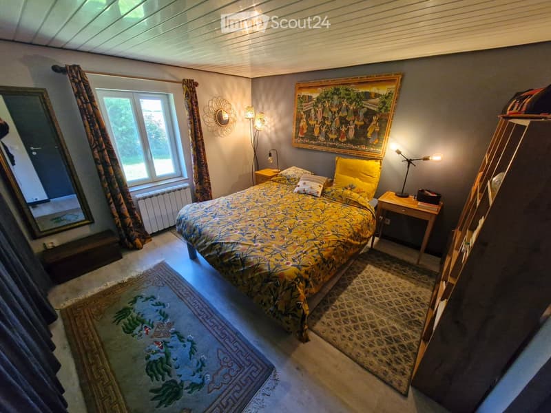 Bedroom. Cozy bedroom with a large bed, nightstands, a mirror, and a painting on the wall. The room features patterned rugs and curtains, creating a warm and inviting atmosphere.