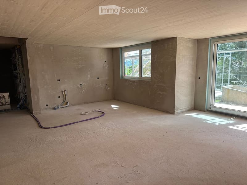 Unfurnished Room. Empty room with unfinished walls, concrete floor, and large windows, including a sliding glass door leading outside.