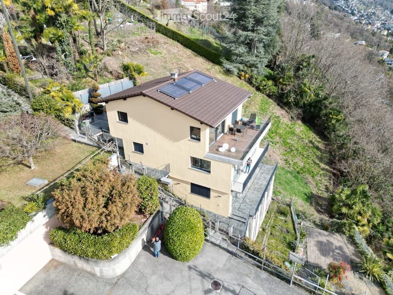 two story house, brown roof, solar panels, balcony, large driveway, garden