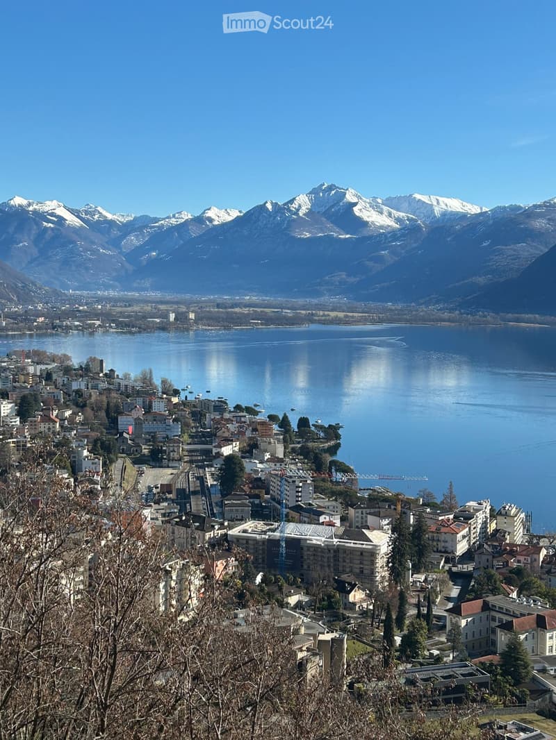 Lake Lugano, mountains, town, buildings, snow-capped peaks, distant city, clear sky