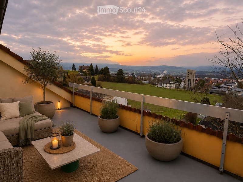 Balcony with a view of a landscape, featuring a sofa, coffee table, and potted plants.