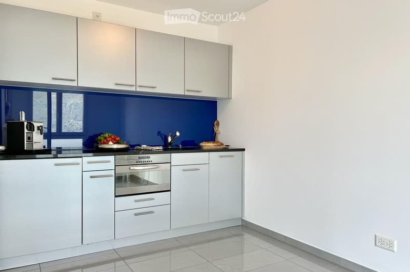 modern kitchen with white cabinets, blue backsplash, stainless steel oven, modern fixtures