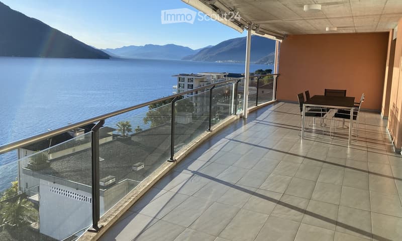 a balcony with glass railings, outdoor dining table and chairs, stunning sea view
