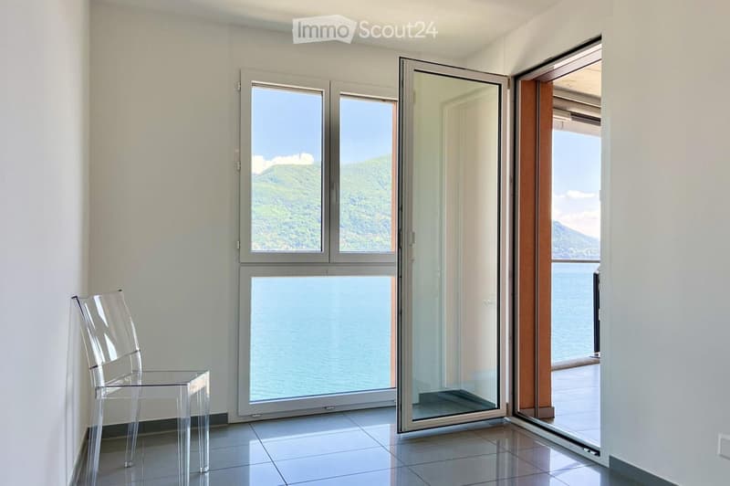 clear modern furniture, windows overlooking lake and mountains, balcony