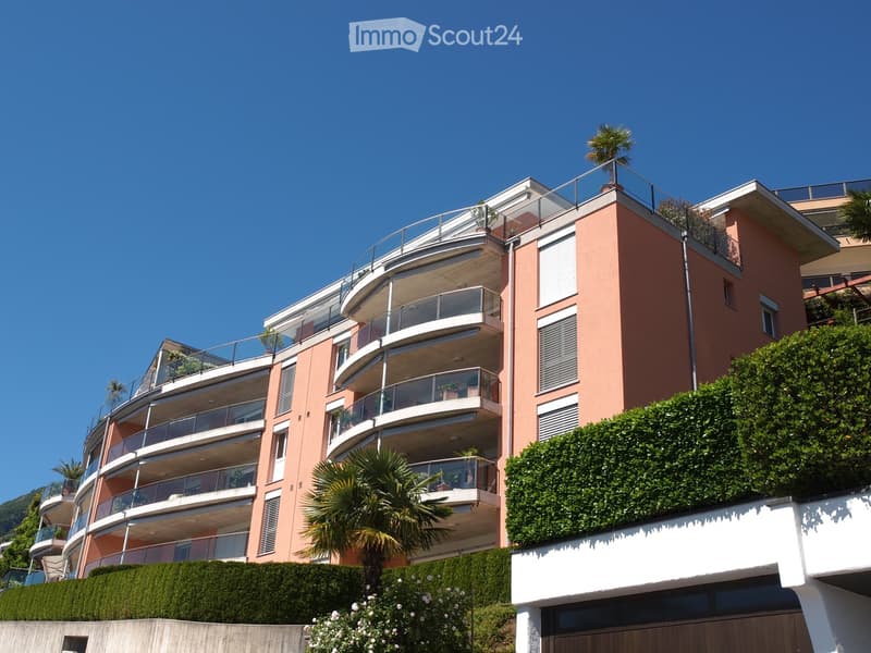 Apartment building, balcony on each floor, greenery, multiple floors, south facing
