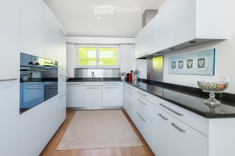 Kitchen. Modern kitchen with white cabinets, stainless steel appliances, black countertop, and a decorative bowl on the counter.