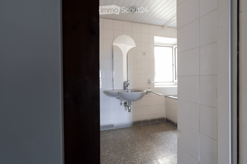 Bathroom. Modern bathroom with white tiled walls, a double sink, a mirror, and a window providing natural light.