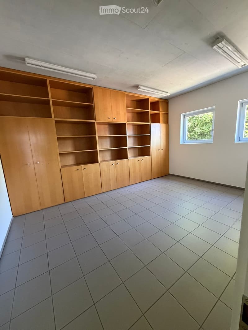 Unfurnished Room. Empty room with tiled floor, wooden built-in shelving unit, and two windows letting in natural light.