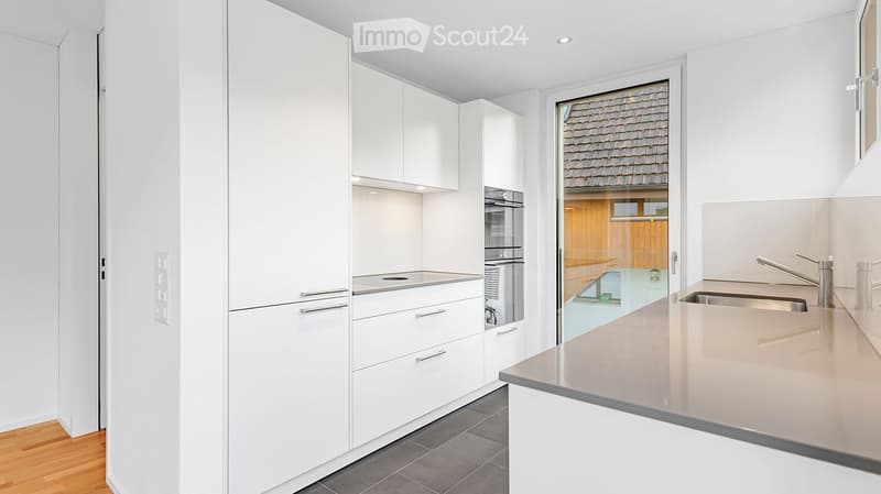 Kitchen. Modern kitchen with white cabinets, stainless steel appliances, and a light-colored countertop.