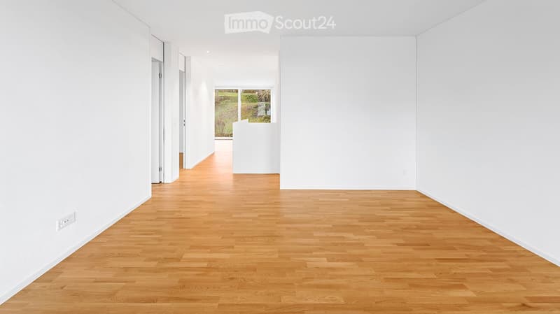 Unfurnished Room. Empty hallway with light wooden flooring and white walls, featuring a large window at the end that lets in natural light.