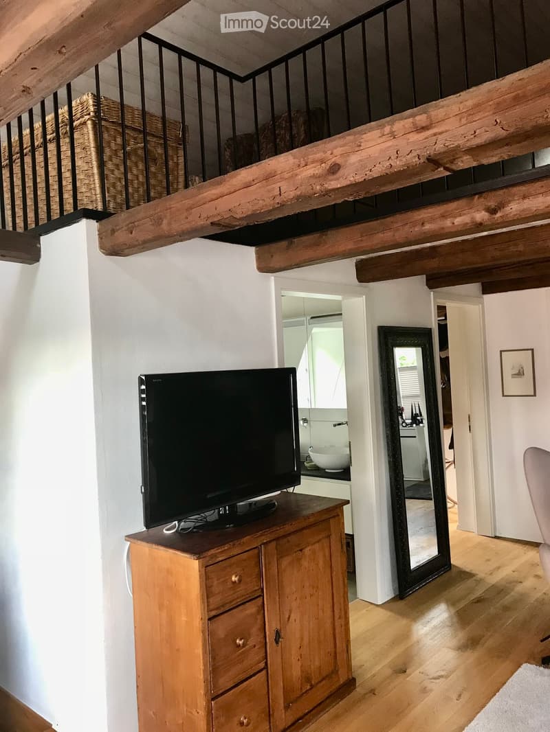 wooden cabinet with flat screen TV, wooden floor, wooden ceiling, stairs to upper floor