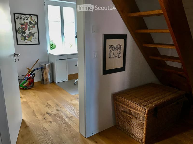 wooden floor, wall-mounted power outlet, wicker storage box, open door, basket of tools