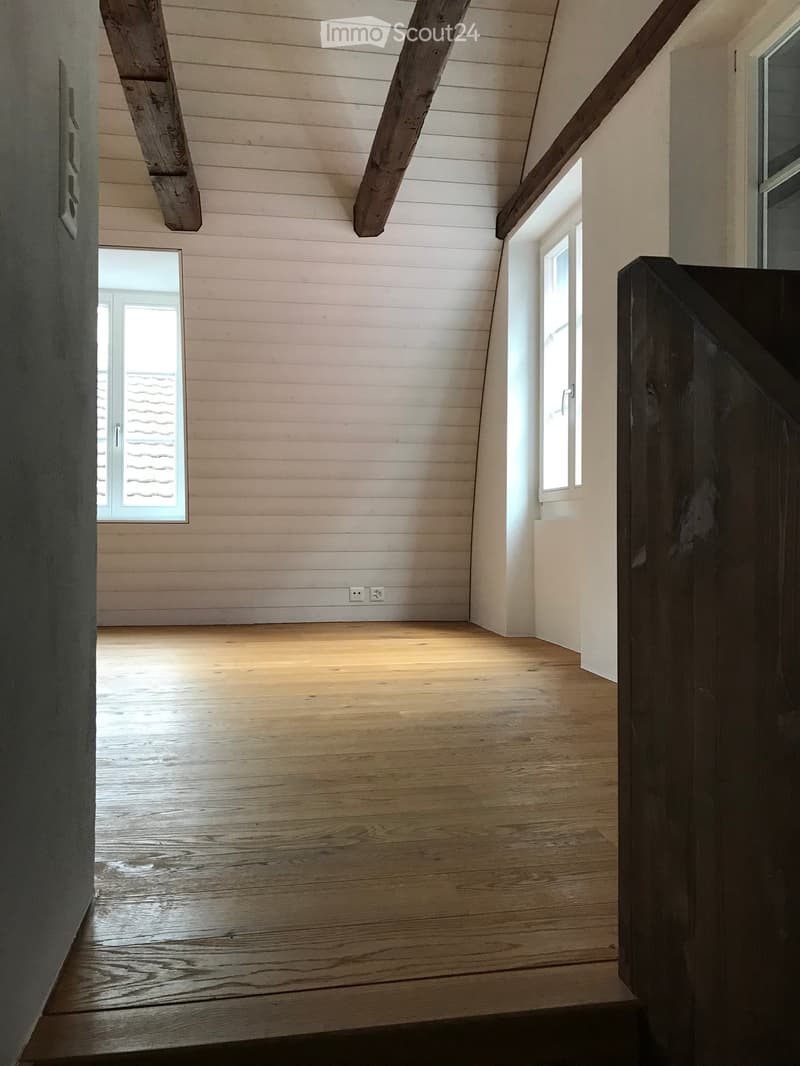large room, wooden beams, wooden floor, empty
